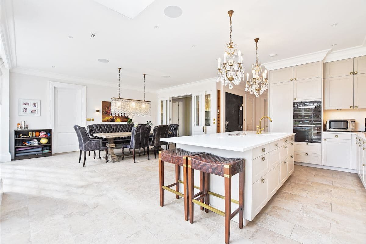 Decorative chandeliers and linear pendants over a kitchen island and dining table